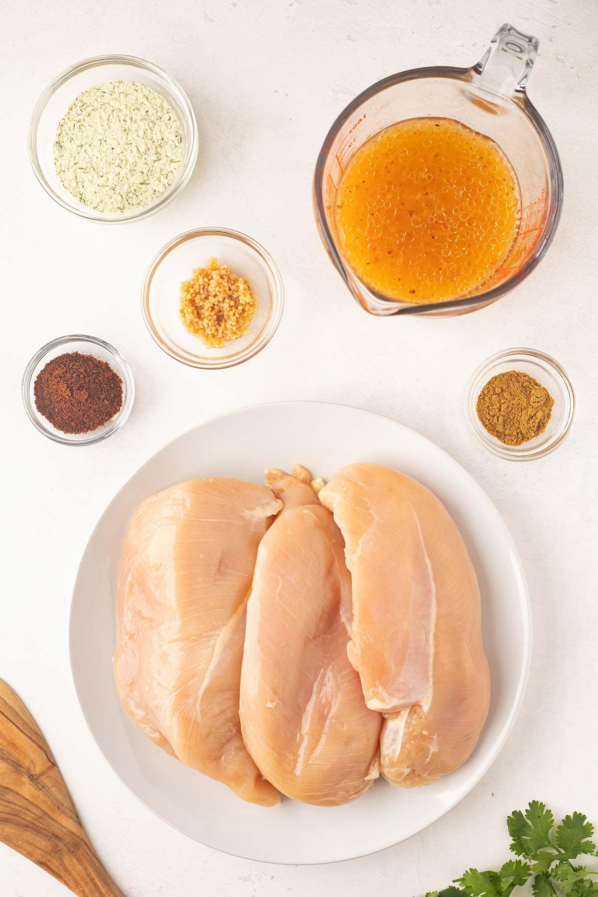 Ingredients to make Copycat Cafe Rio Chicken sitting on a butcher block counter.