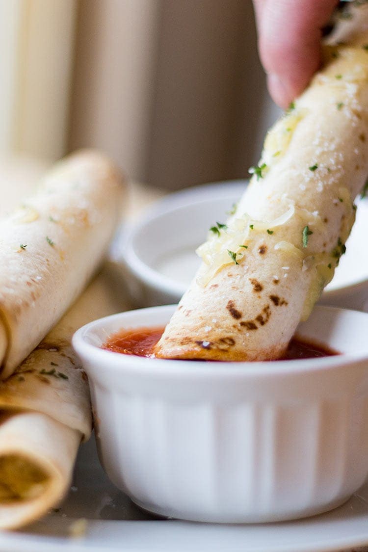 Picture of a Chicken Bacon Ranch Taquito being dipped into salsa.