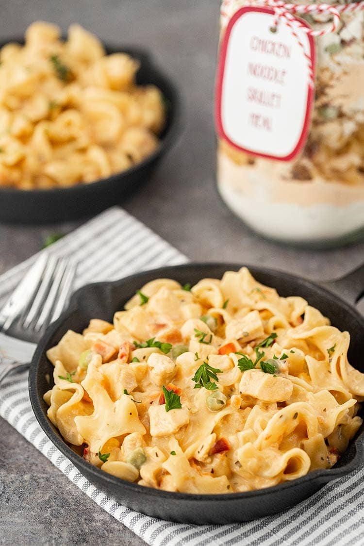 Chicken Noodle Skillet Meal in a Jar, made into a meal and served in small cast-iron skillets, garnished with fresh parsley.