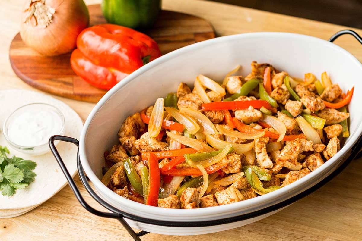 White baking dish with freezer fajitas baked and ready to eat.