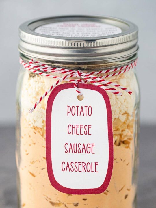 Cropped shot showing quart mason jar filled with the dry ingredients for making Potato Cheese Casserole as a shelf-stable meal in a jar.