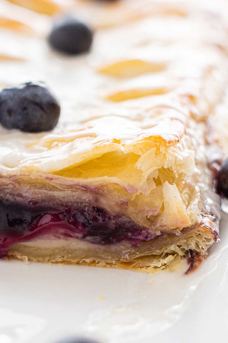 Closeup shot of Make-Ahead Blueberry Cream Cheese Danish showing the blueberry and cream cheese filling after baking.