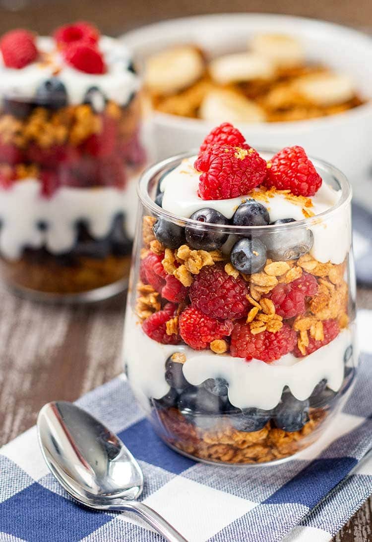 Glass with Easy Peanut Butter Granola cereal used in a fruit and yogurt parfait.