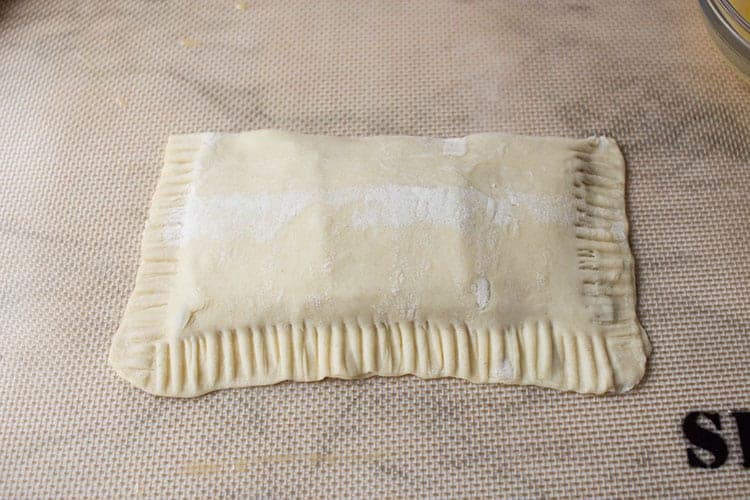 Folded puff pastry hot pocket on silicone mat.