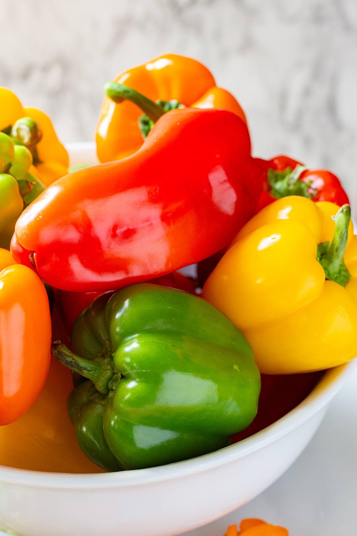 A whole of whole bell peppers of various colors and sizes.