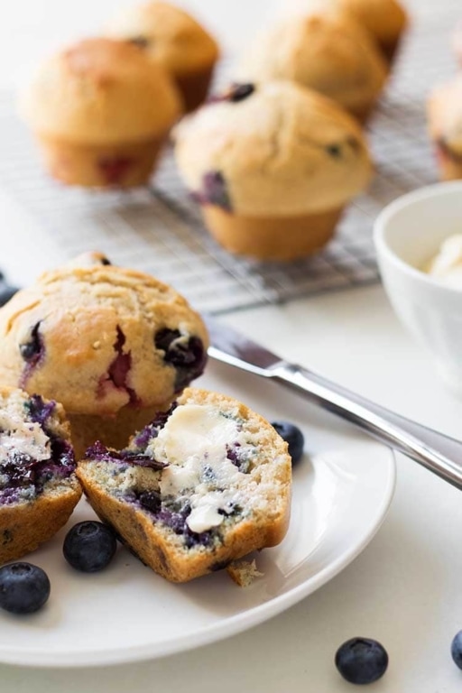 Blueberry muffins on a tray and plate, made from the Make-Ahead Muffin Mix recipe.