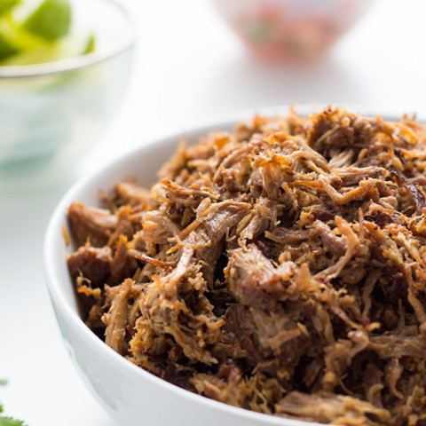 Mexican Pulled Pork Carnitas shredded in bowl with garnishes
