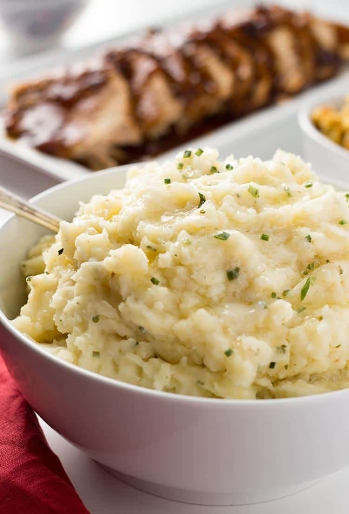 Garlic Herb Mashed Potatoes in a bowl on the table with dinner