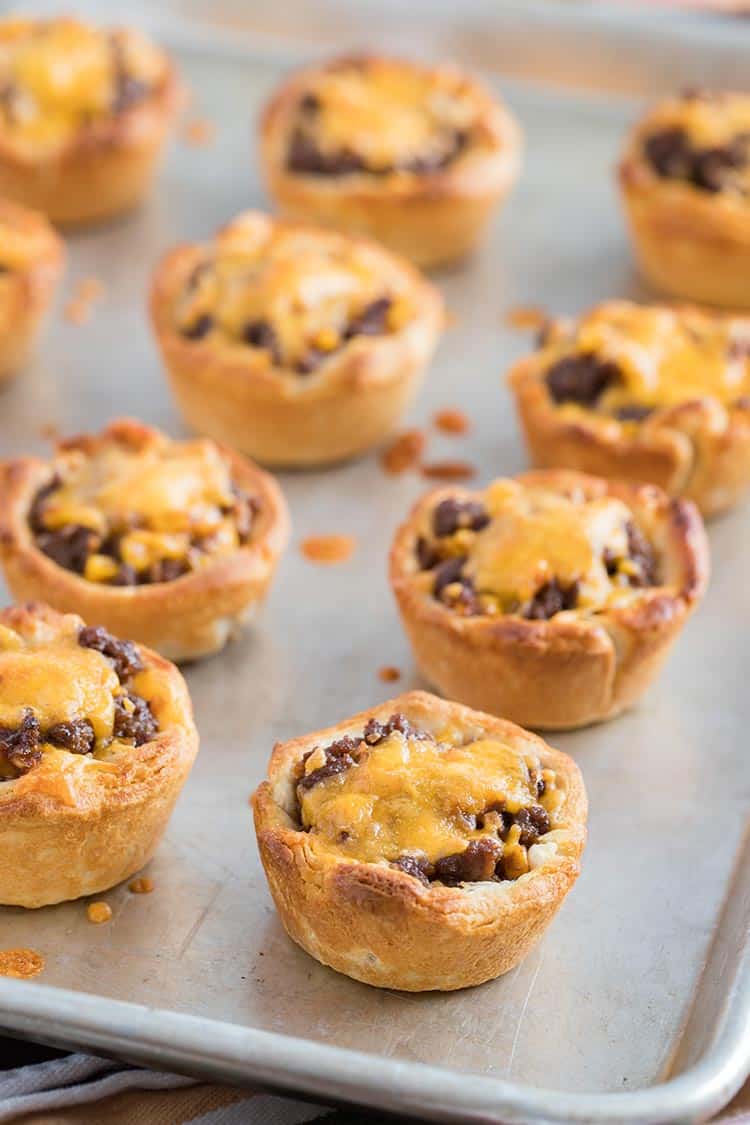 Beefy Barbecue Biscuit Cups baked on tray and topped with melted cheese ready to eat