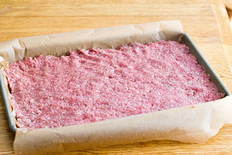 Teriyaki Slider meat mixture spread in quarter-sheet pan ready for baking