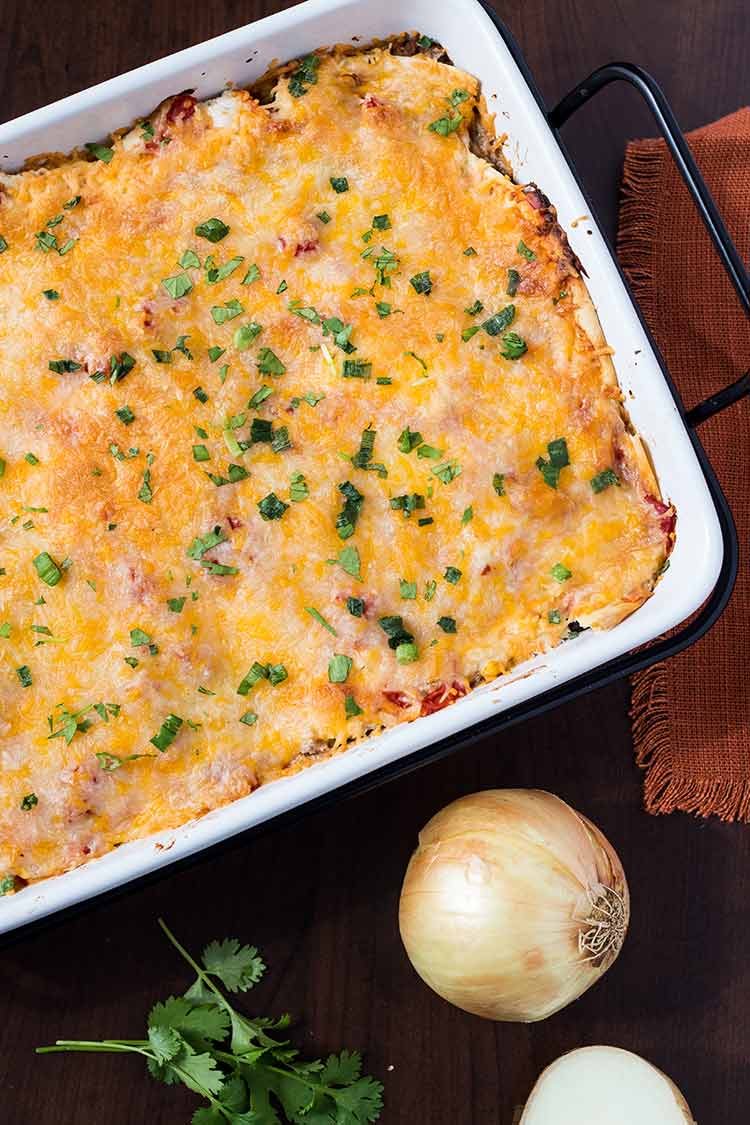 Overhead shot of Make-Ahead Mexican Lasagan in a baking dish and garnished with chopped cilantro