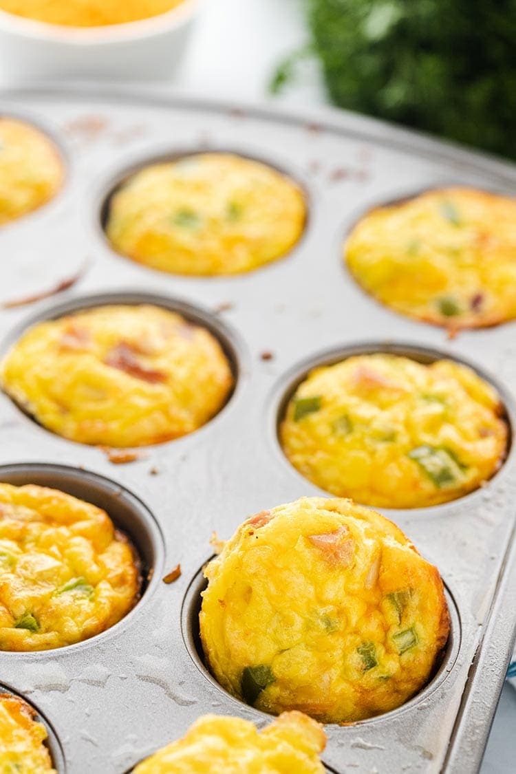 A muffin tin full of baked Denver Omelet Egg Muffins ready to package for the freezer