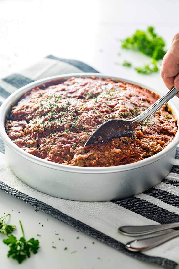 Instant Pot Meatloaf in a pan being dished up for dinner.