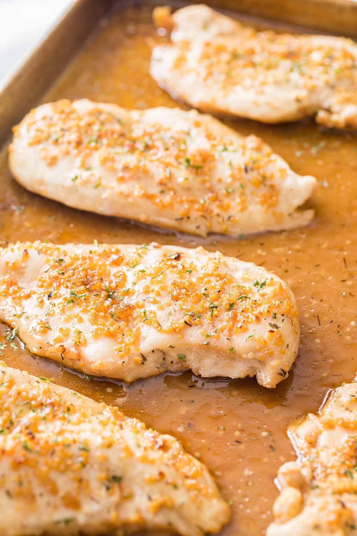 Garlic Brown Sugar Chicken on a baking sheet, garnished with fresh parsley.