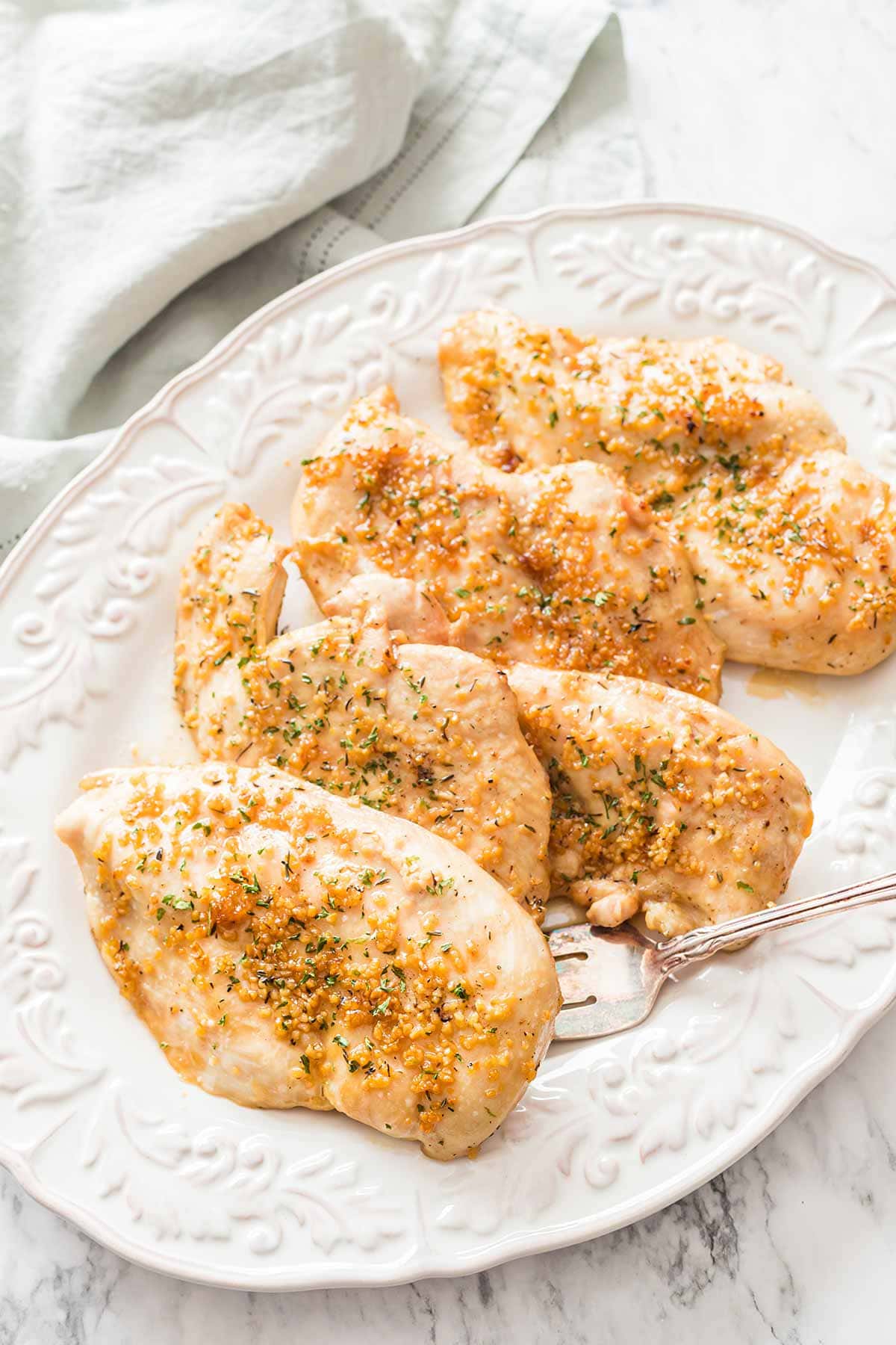 Overhead shot of five pieces of Baked Garlic Brown Sugar Chicken on white serving platter.