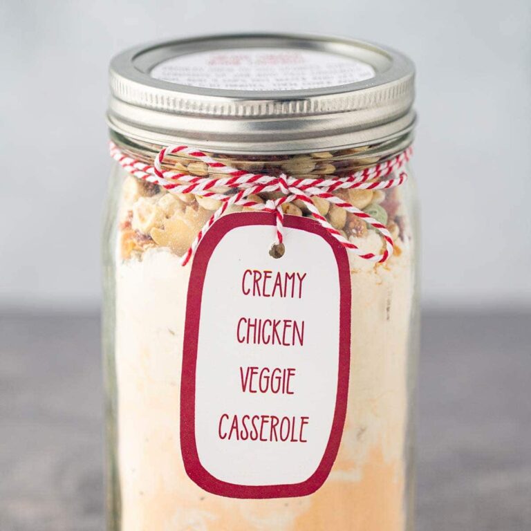 Mason jar filled with dry ingredients used in Creamy Chicken Veggie Casserole, with printed label tied on to outside of jar.