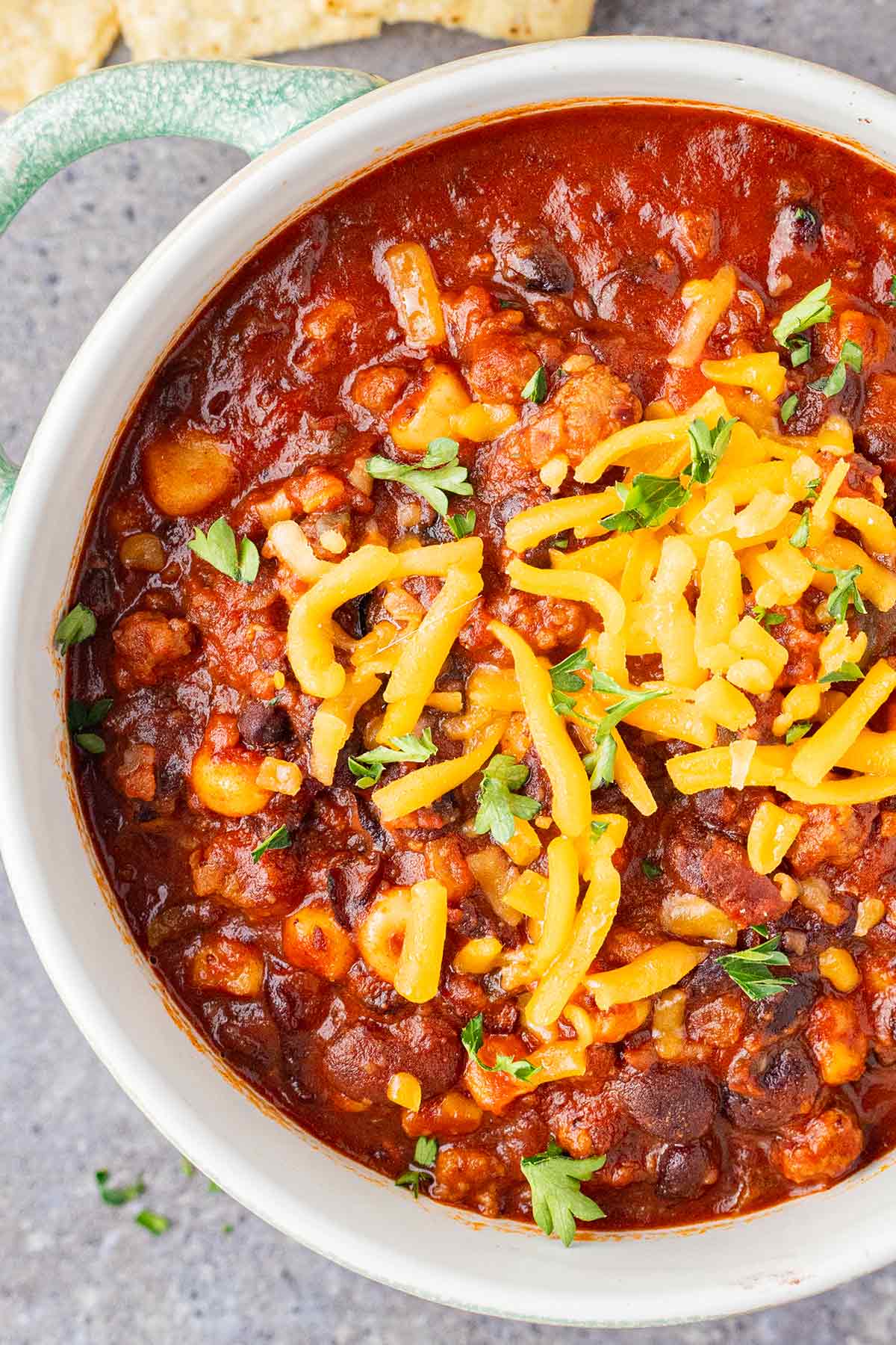 Overhead shot of Taco Soup in a Jar as made for a meal, with tortilla chips and shredded cheese.