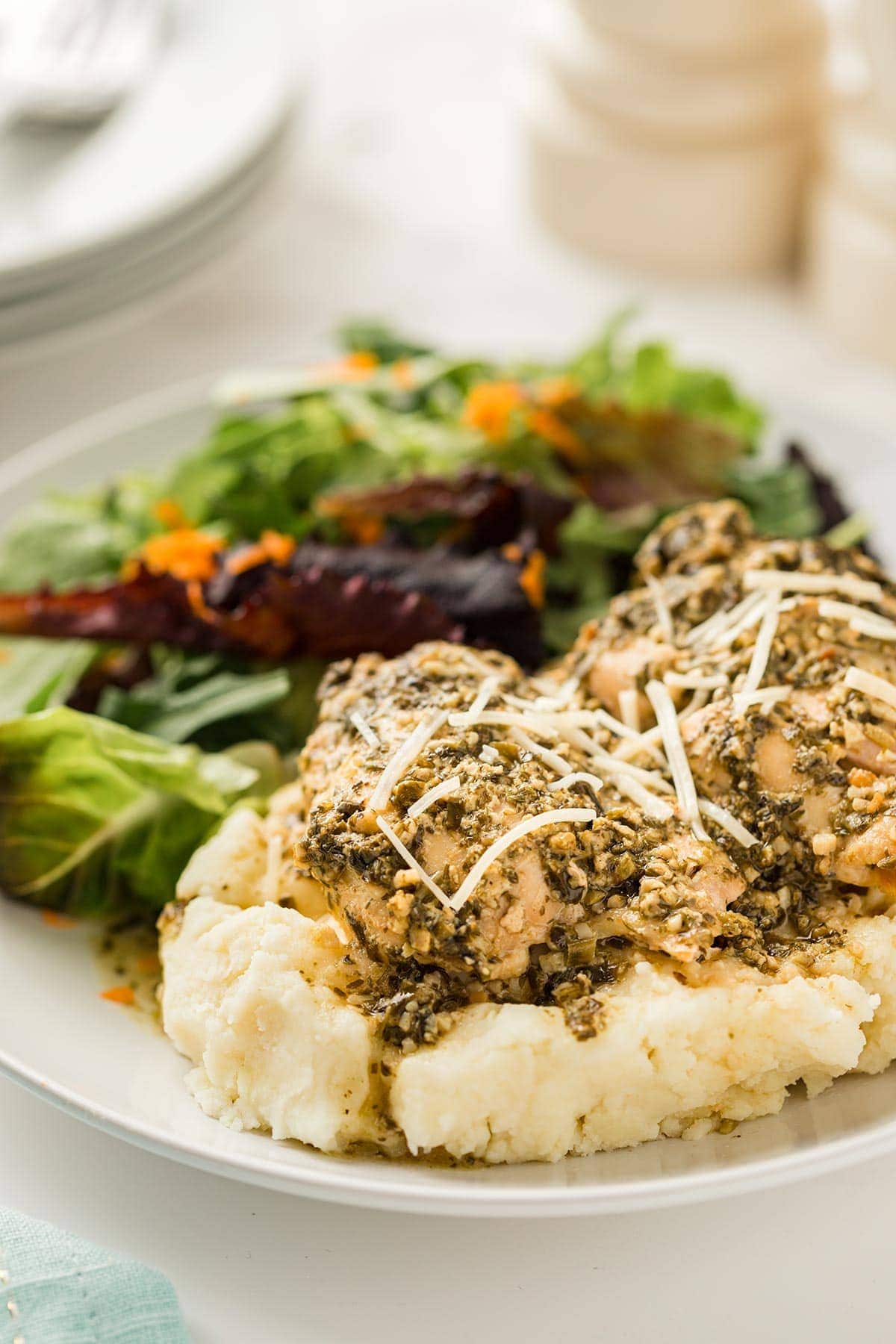 Dinner plate with Pesto Ranch Chicken on top of mashed potatoes.