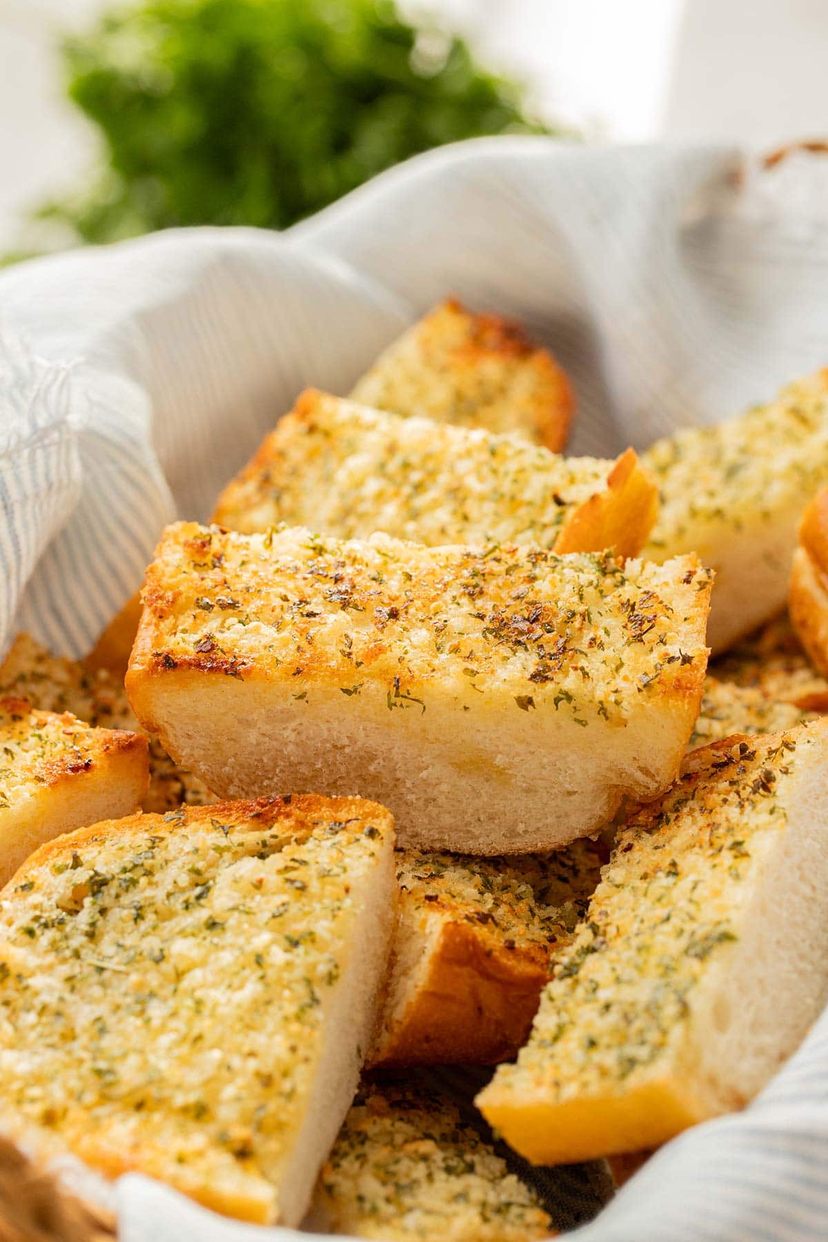 Slices of make-ahead freezer garlic bread in a basket on a table.