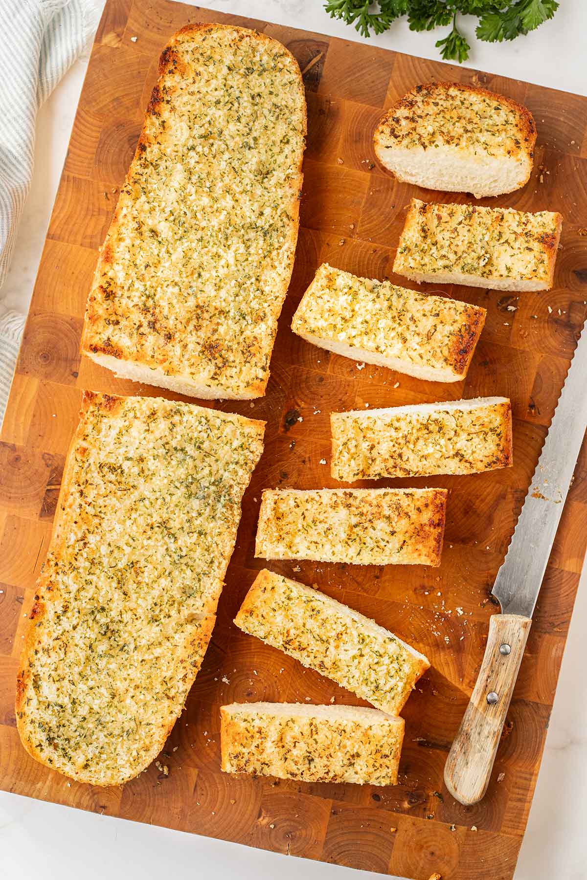 Make-Ahead Freezer Garlic Bread on a wooden cutting board, cut into slices.