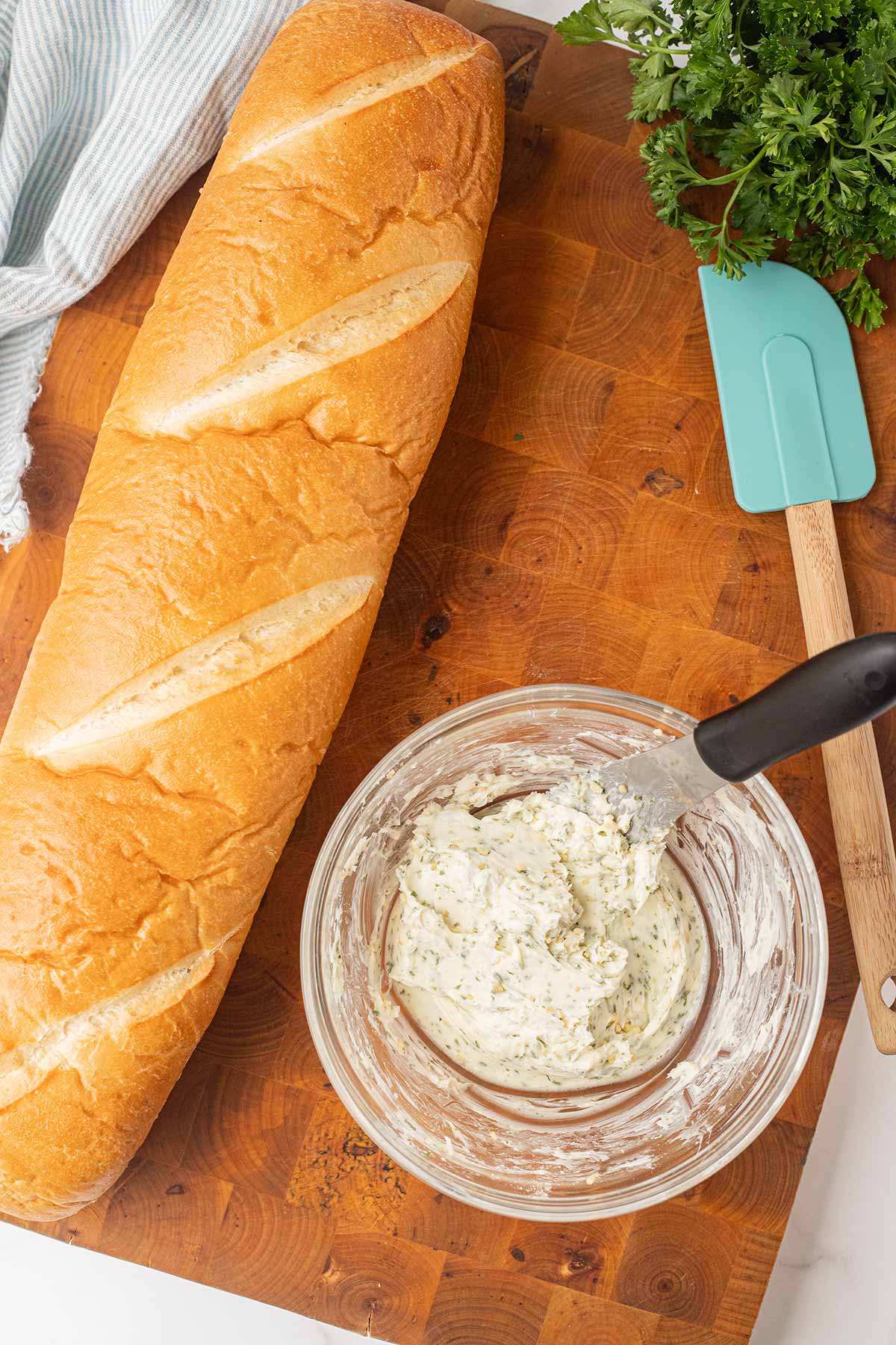 Process shot showing how to mix the garlic butter spread for make-ahead freezer garlic bread.