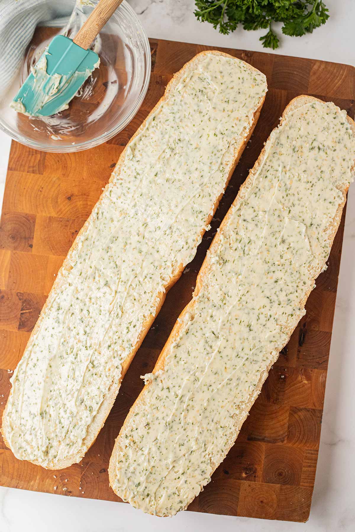 Process shot showing how to spread the garlic butter mixture onto make-ahead freezer garlic bread.