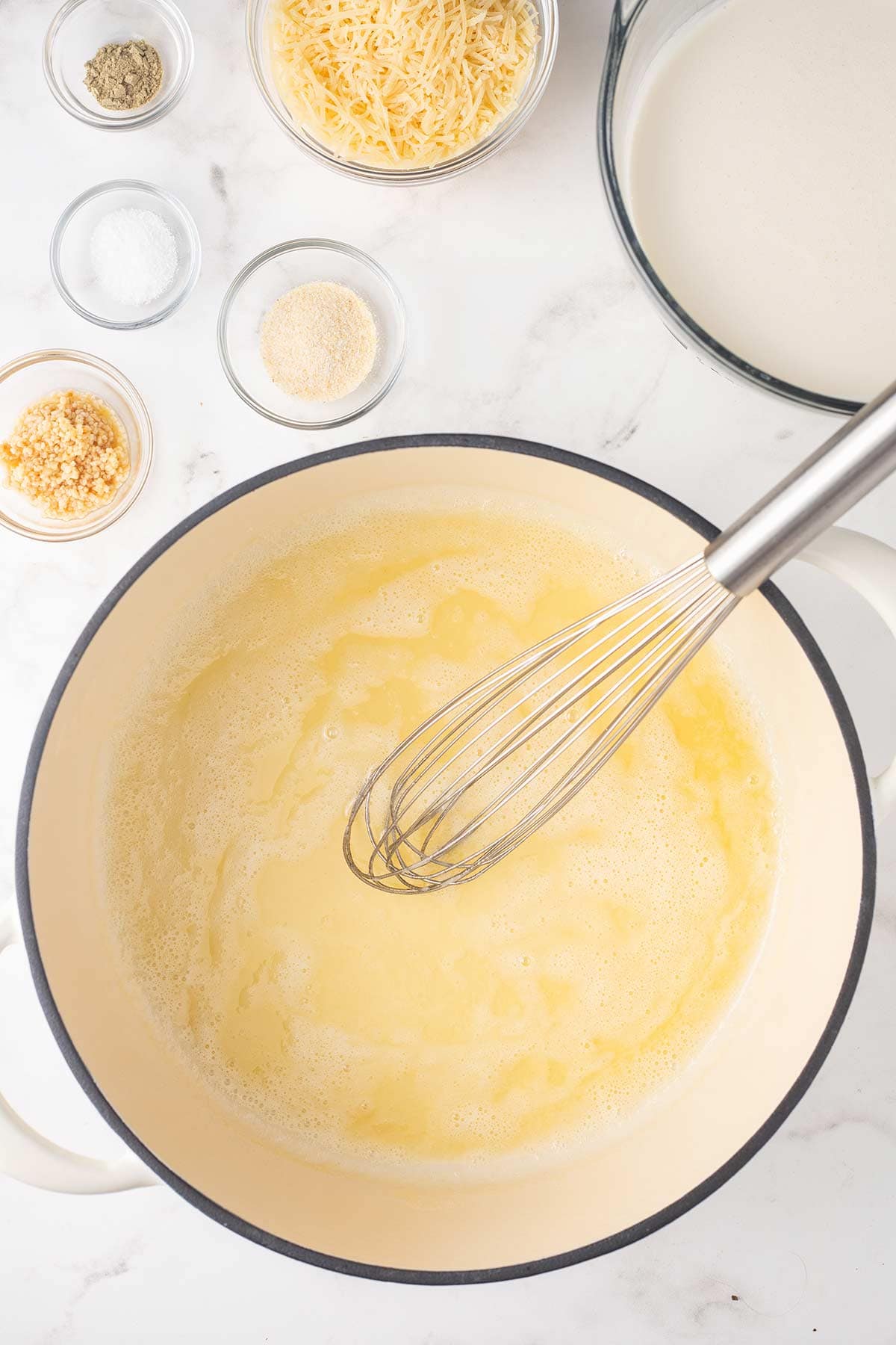 Melted butter in a dutch oven for making Chicken Alfredo Bake.