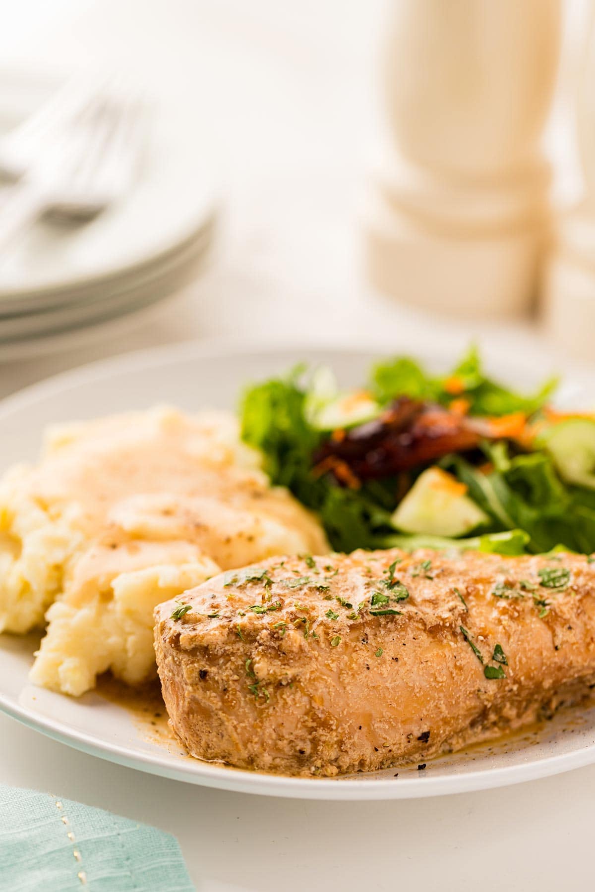 Photo of Slow Cooker French Onion Chicken on a plate with mashed potatoes and a green salad.
