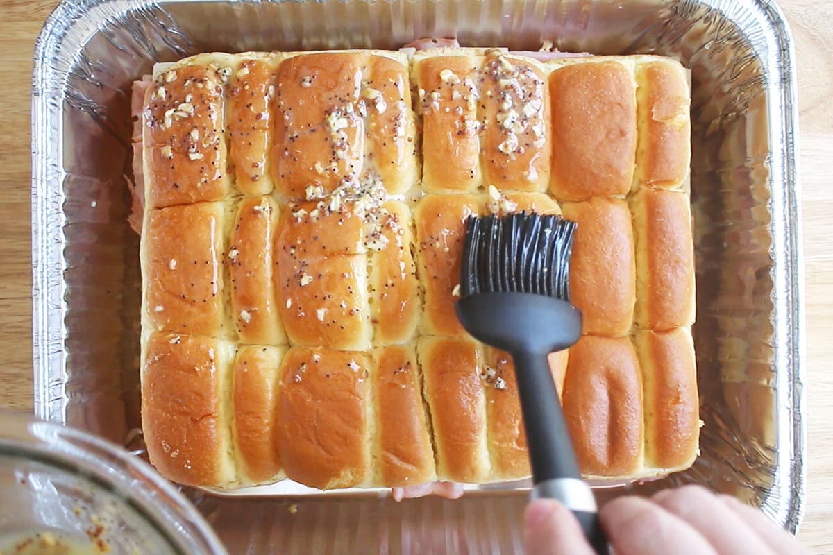 Overhead shot showing how to add butter topping to the make ahead sliders.