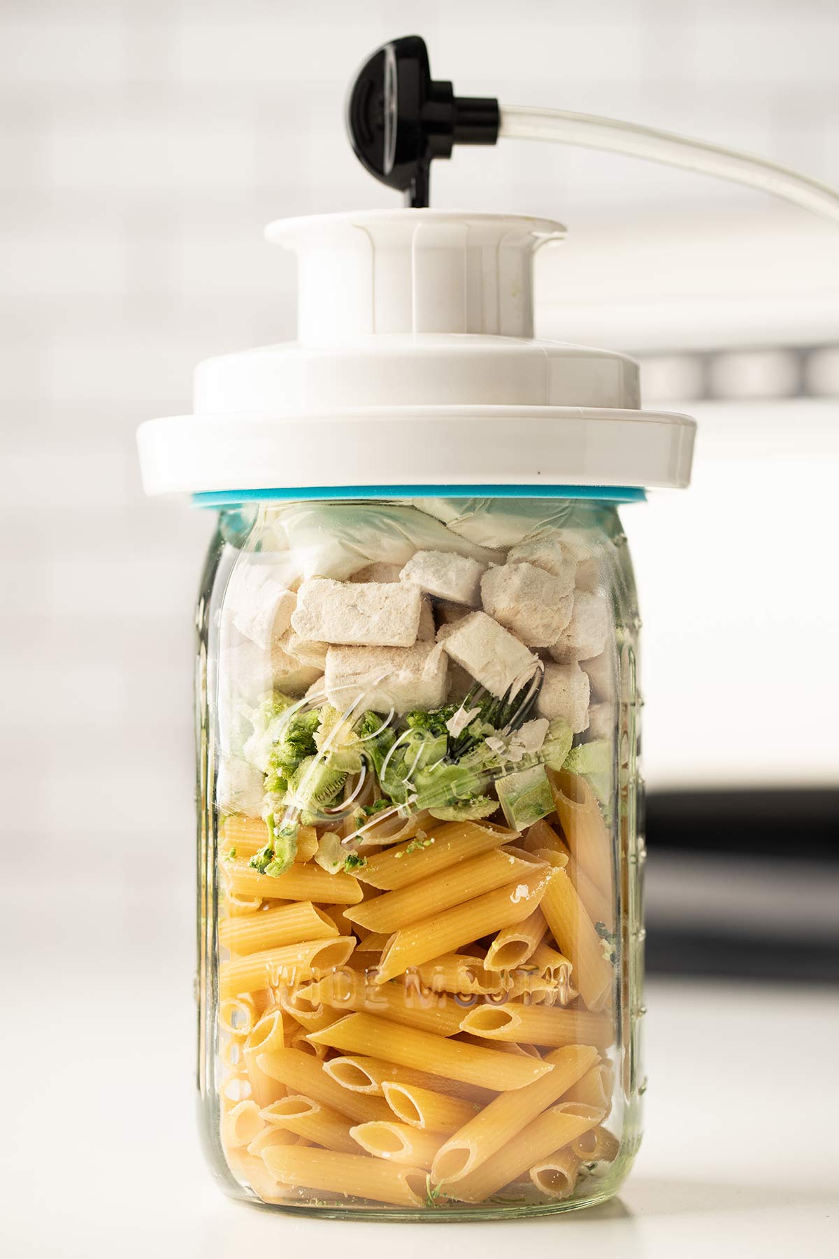 Jar sealer attachment being used to vacuum seal the Chicken Broccoli Alfredo meal in a jar.