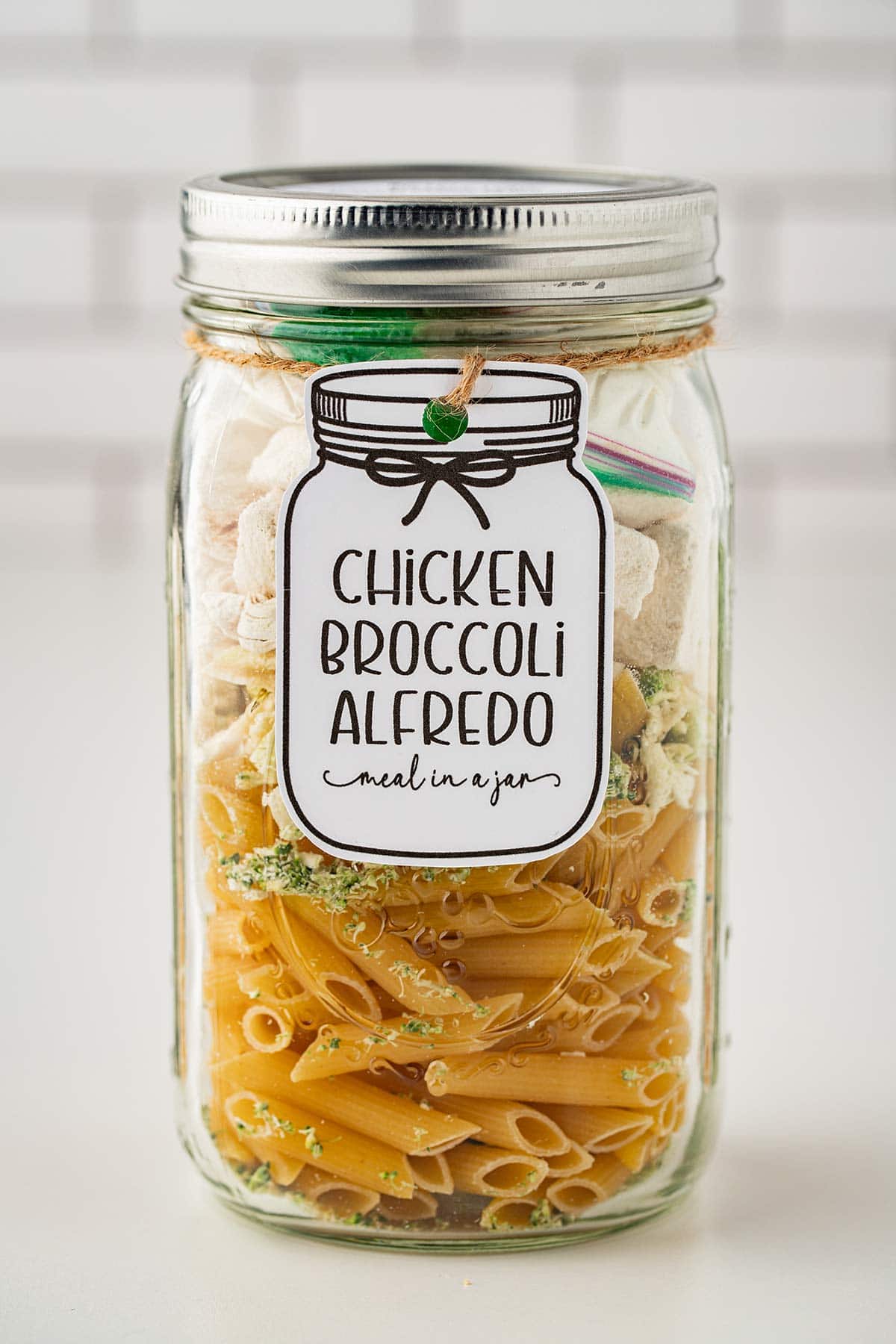 Front shot of Chicken Broccoli Alfredo meal in a jar with a gift tag affixed.